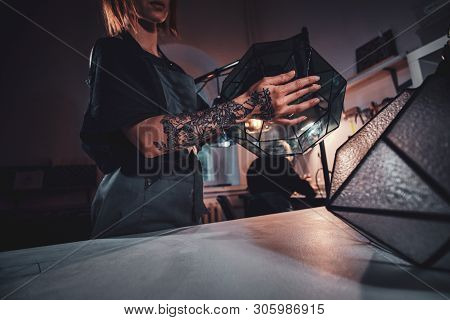 Talanted Young Designer With Tattoo On Her Hand Is Prepearing New Lamp, She Is Holdind It In Hands.