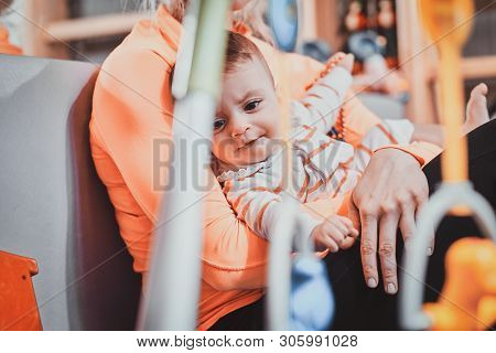 Joyful Happy Mom Is Playing With Her Newborn Baby While Waiting For A Doctor At Pedeatrician Cabinet