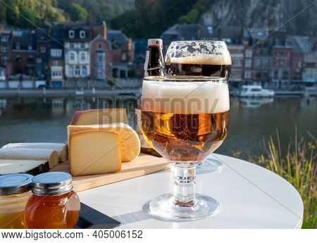 Drinking Of Dark And Strong Belgian Abbey Beer With Cheeses With Nice View On Maas River And Town Di