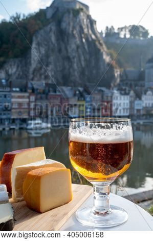 Drinking Of Dark And Strong Belgian Abbey Beer With Cheeses With Nice View On Maas River And Town Di