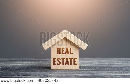 Wooden Figurine Of A House With Word Real Estate. Buying And Selling. Housing, Realtor Services. Con