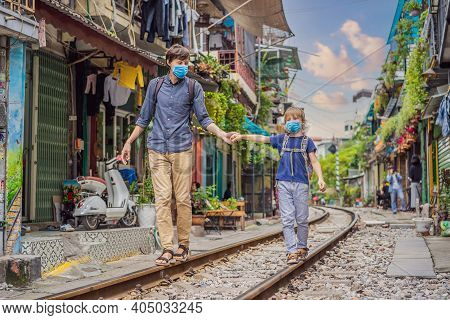 Father And Son Travelers Wearing A Medical Mask During Covid-19 Coronavirus Walk Around Railway Path