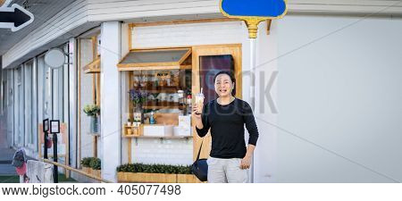 Asian Man In The Black T-shirt Holds The Bubble Ball Ice Milk Tea In Front Of The Shop On The Outdoo