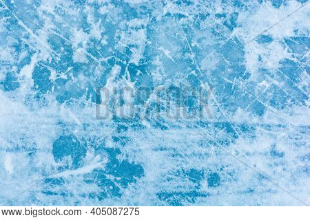 Ice Blue Background With Skate Tracks. Skating Rink. Frozen Water, Sea. Frosty Ice Texture With Scra