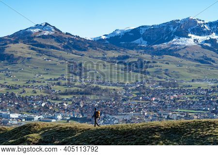 Hiker Walking Down From Hintere Hoehi Towards The Village Appenzell, Switzerland