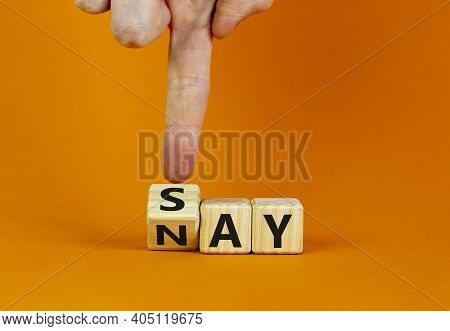 Say Nay Symbol. Businessman Turns A Cube, Changes The Word 'say' To 'nay'. Beautiful Orange Backgrou
