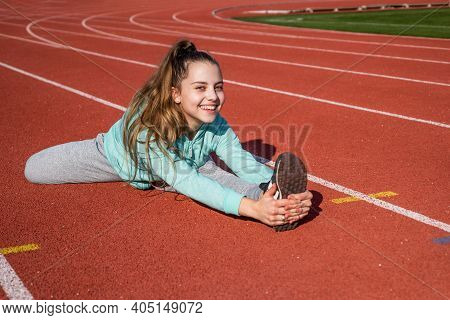 Sporty Beauty. Confident Flexible Athlete. Teen Girl Warming Up On Stadium. Kid In Sportswear Stretc