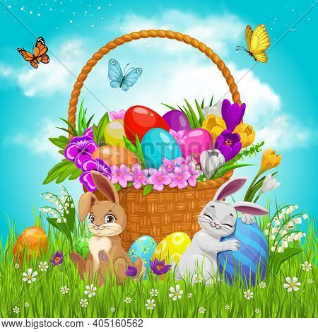 Easter Basket With Flowers, Painted Eggs And Bunnies On Green Lawn With Flying Butterflies Under Clo
