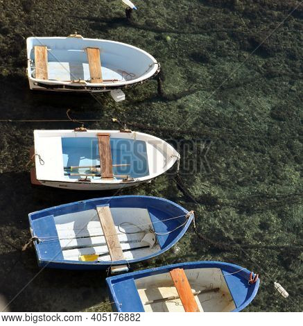 Small Blue Row Boats Bobbing In Clear Water In Harbor. High Quality Photo
