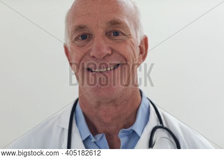Portrait of senior caucasian male doctor looking at the camera and smiling. medical professional worker.