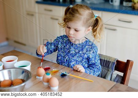 Excited Little Toddler Girl Coloring Eggs For Easter. Cute Happy Child Looking Surprised At Colorful