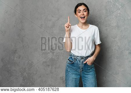 Portrait of cheerful young woman prsenting copy space while standing over isolated background