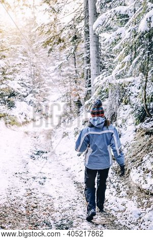 Young Woman In A Sports Suit Walks Down The Mountain Path. Warm Sunlight Seeable On Horizont. Hiker 