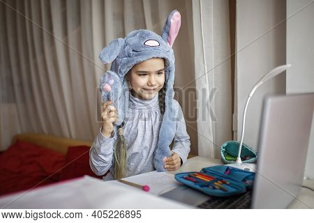 Distant Education, Online Class Meeting. Girl Wearing Funny Hat For Amusement During Online Lesson