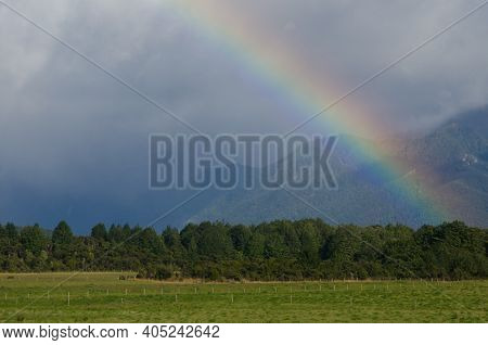 Rainbow In Southland. Southland And Fiorland National Park In The Background. South Island. New Zeal