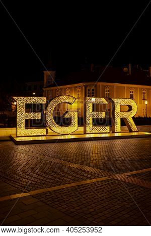 illuminated sign Egger in center of historic city, Northern Hungary