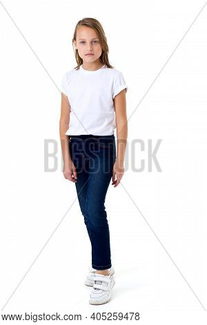 Blonde In A White T-shirt. Pretty Stylish Girl Posing In Studio On A White Background. Full-length P