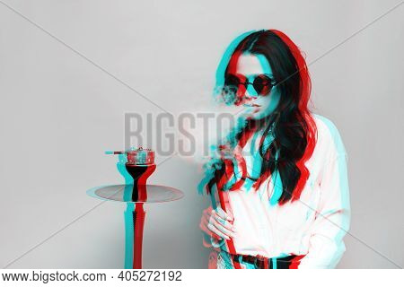 An Attractive Woman In A Hipster Image Smokes A Hookah, Sheesha And Enjoys Smoking. Black And White 