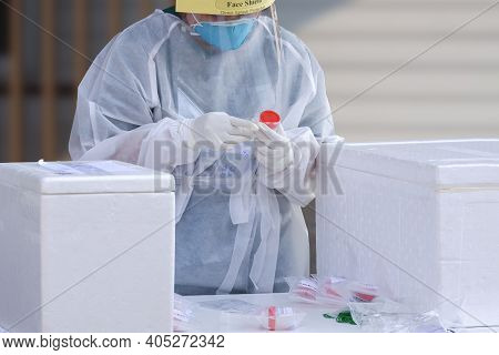 Female Health Worker In Ppe Clothing Collects Sputum And Saliva Samples To Detect Covid-19 Infectiou