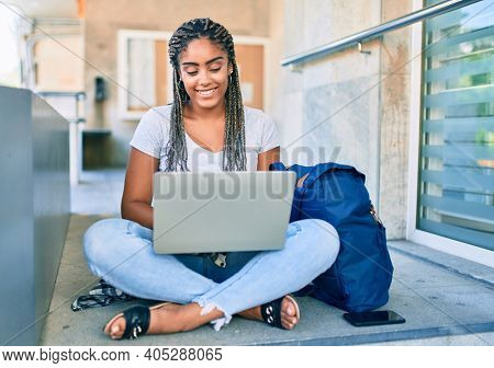 Young african american student woman smiling happy using computer laptop at the university campus