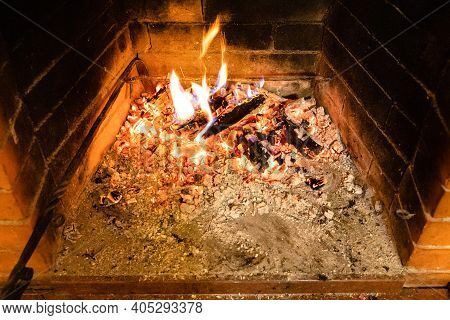 Above View Of Smoldering Firewood And Ash In Home Brick Fireplace