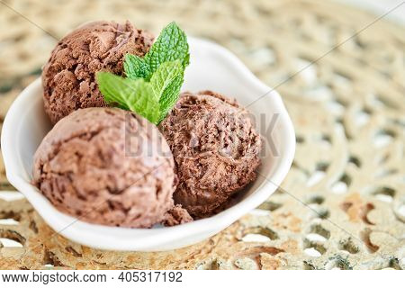Chocolate Ice Cream With Mint Leafe. Three Balls In A White Bowl On A Vintage Table.