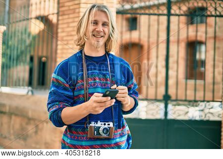 Young scandinavian tourist man smiling happy using smartphone at the city.