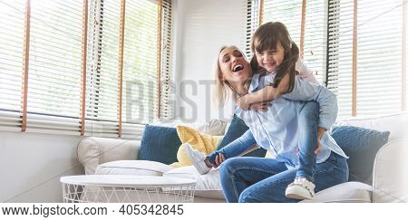 Happy Beautiful Mother Carrying Or Piggyback Her Little Daughter Laughing Playing And Having Fun Tog