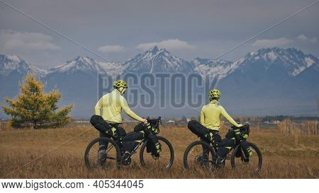 The Man And Woman Travel On Mixed Terrain Cycle Touring With Bikepacking. The Love Couple Journey Wi
