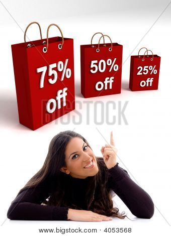 Posa donna indicando le borse della spesa