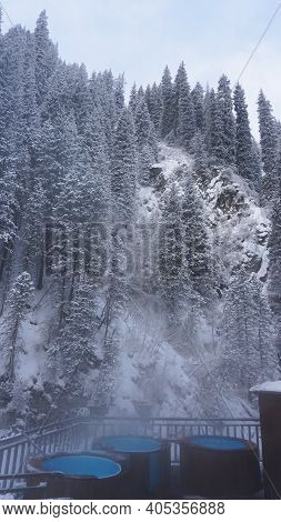 There Is Steam From Barrels With Hot Springs. Warm Radon Clean River. Bridge And Metal Structures Fo