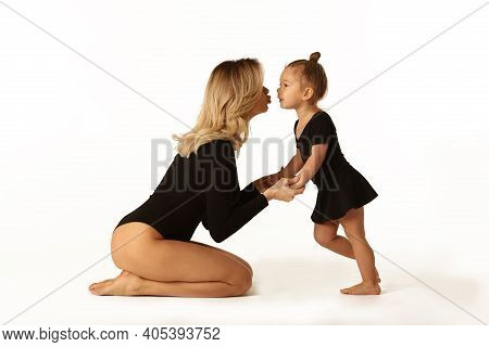 Cute Baby Girl And Mum In Black Bodies Having Fun Full Body Studio Portrait