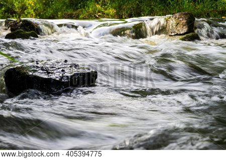 River Flow Over Rocks In Summer Day. Waves Of The River Flow. Relaxing Nature Landscape Scenics