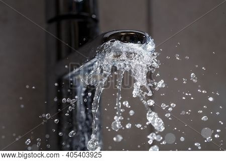 Broken Water Faucet In The Bathroom Sink. Water Splashes From The Silver Faucet