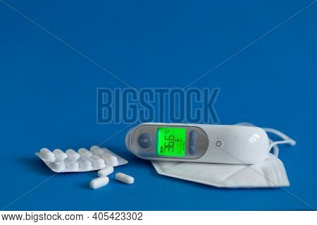 Ffp3 Mask, Nasal Drops, Thermometer, Tablets, Various Medicines Lie On The Table, Top View, On A Blu
