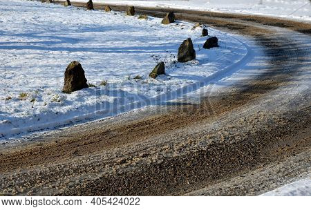 A Snowy Meadow And A Dirt Road With A Clattering Mud In A Bend. So That The Vehicles Orient Themselv