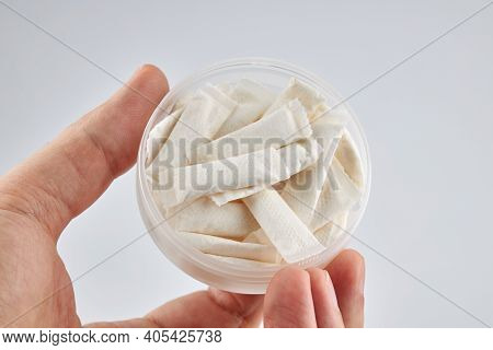 Snus Nicotine Product At Hand Palm. Copy Space. Stack Of White Small Bags In The Hand.