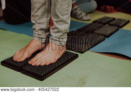Group Practice Of Standing On Nails. Closeup Of Yoga Person Standing On Sadhu Board With Sharp Nails