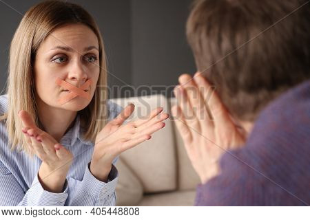 Young Woman With Sealed Mouth Showing Gestures To Man. Psychological Family Problems Concept