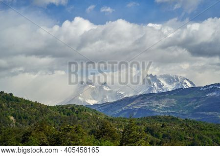 Horns Of Torres Del Paine Towering Over A Mountain Ridge With Dark Green Forest At Torres Del Paine 