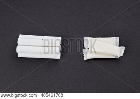 Snus Tobacco Pouches And Cigarettes Over Black Background.