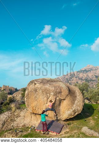 Two Young Girls Climb Bouldering Outdoors. Rock Climber Climbs A Difficult Route. Do Sports Outside 