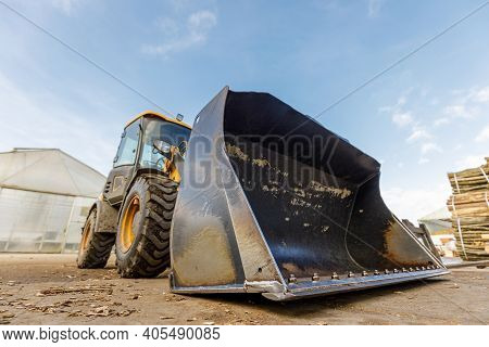 Low Angle Shoot Of A Small Tractor Or Escavator. Industrial Concept.