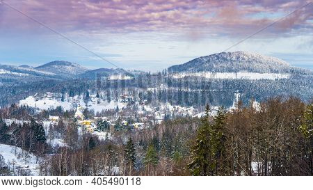Snowy Winter Hilly Landscape. Beautiful Rural Range. Panorama With Sokol Mountain And Kytlice Villag