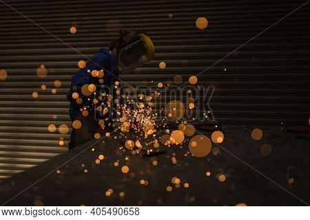 Female welder using welding torch in workshop