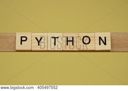 Word Pyton Made From Wooden Letters Lies On A Yellow Table