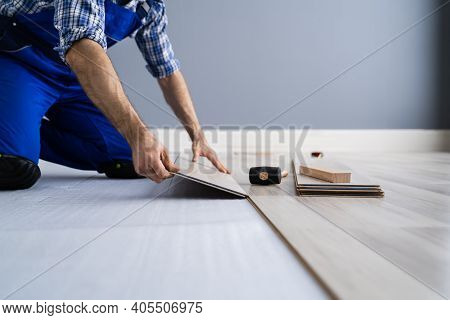 Hardwood Floor Renovation. Construction Worker Doing New Laminate Installation