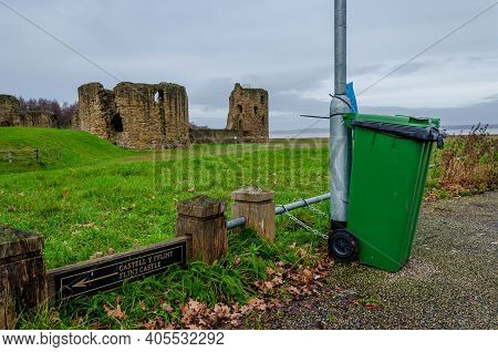 Flint; Uk: Jan 28, 2021: A Green Wheelie Bin Is Securely Fastened To A Lamp Post Using Chains And St