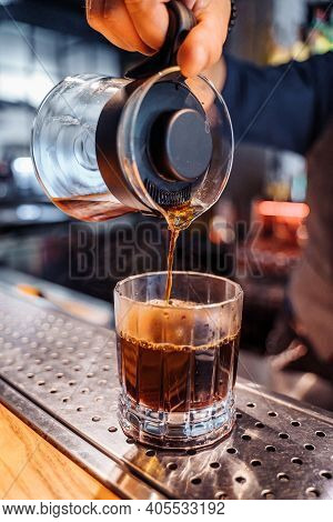 Close Up Of Young Caucasian Bearded Male Barista Hands Pouring Coffee Into Kalita Wave Dripper Filte