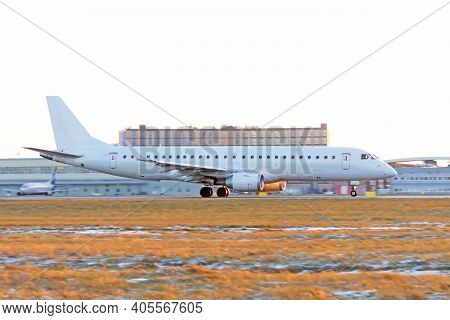 The Plane Is Accelerating Along The Runway Against The Background Of A Teminal